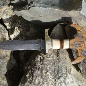 JURASSIC HANDLE DAMASCUS PUSH DAGGER WITH MAMMOTH IVORY, BALTIC AMBER, MASTODON IVORY AND MAMMOTH TOOTH HANDLE WITH FILE WORK.